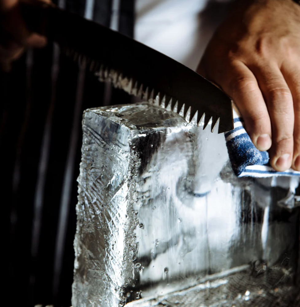 Cutting a clear ice block with a saw