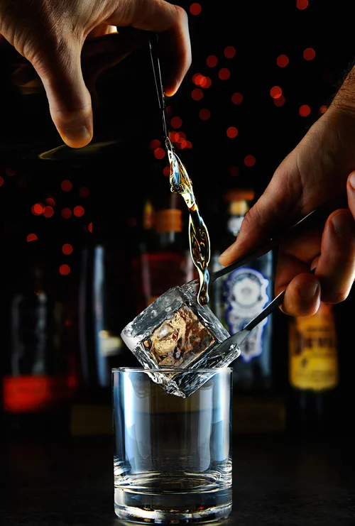 Pouring spirit over clear ice
